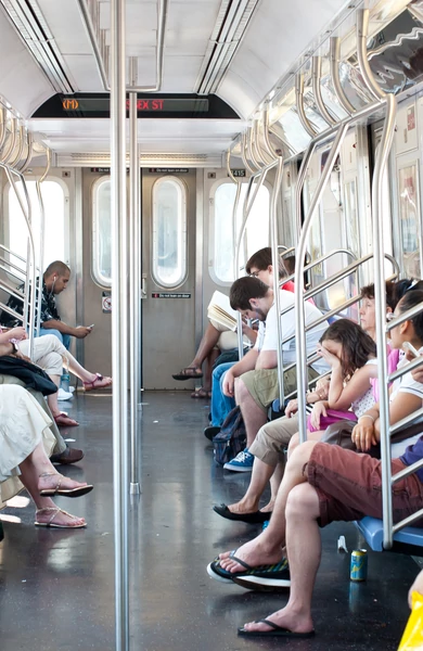 Vagão de trem cheio de pessoas sentadas.