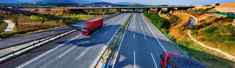 Caminhão trafegando em estrada em rota de transporte de cargas.